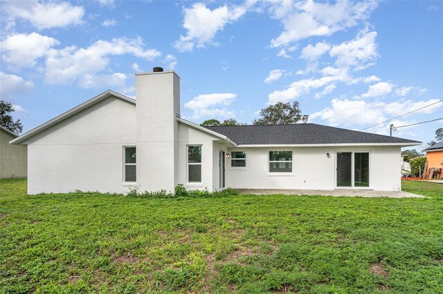 1001 Glencove Ave NW, Palm Bay, FL 32907 - rear view of house featuring a chimney, a yard, a patio, and stucco siding