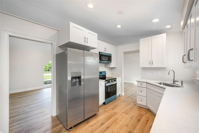 1001 Glencove Ave NW, Palm Bay, FL 32907 - kitchen featuring a sink, light wood-style flooring, white cabinets, appliances with stainless steel finishes, and recessed lighting