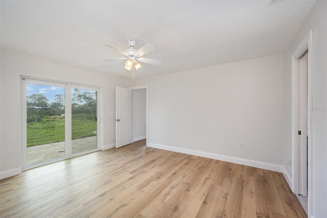 1001 Glencove Ave NW, Palm Bay, FL 32907 - unfurnished bedroom featuring light wood-style flooring, baseboards, ceiling fan, and access to exterior