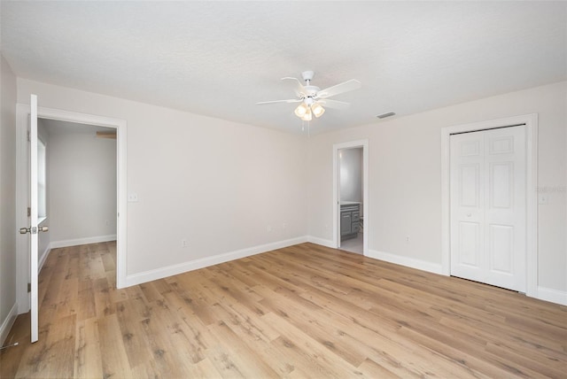 1001 Glencove Ave NW, Palm Bay, FL 32907 - unfurnished bedroom featuring light wood finished floors, baseboards, ensuite bath, and visible vents