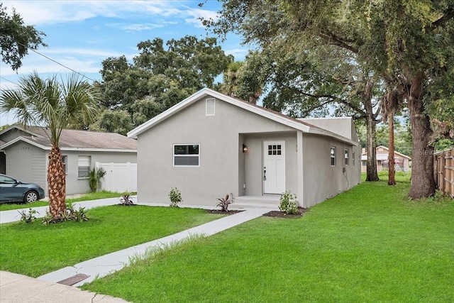 single story home with fence, a front lawn, and stucco siding