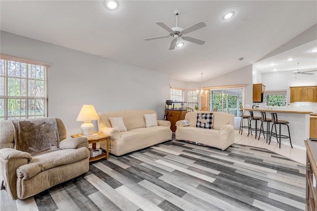 living room with ceiling fan with notable chandelier and lofted ceiling