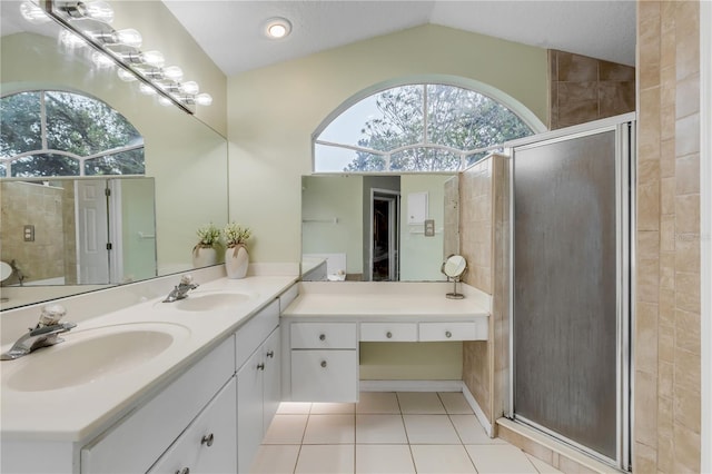 bathroom with lofted ceiling, vanity, tile patterned floors, and walk in shower