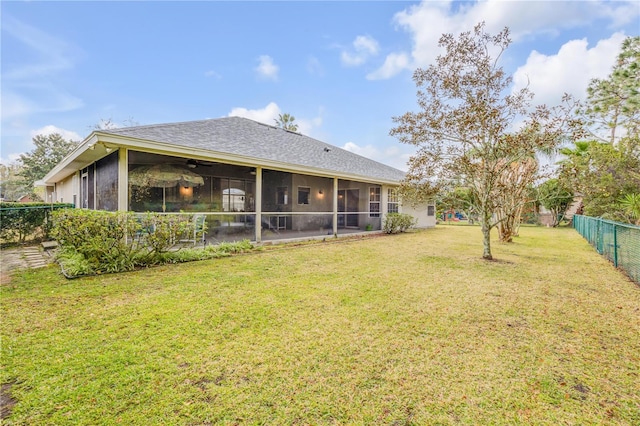 rear view of house with a yard, a sunroom, and ceiling fan