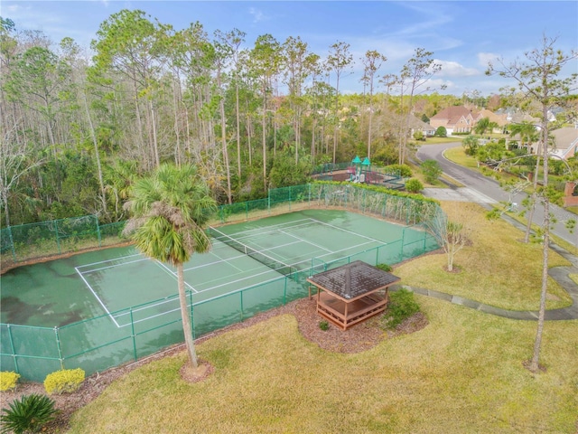 view of tennis court with a yard