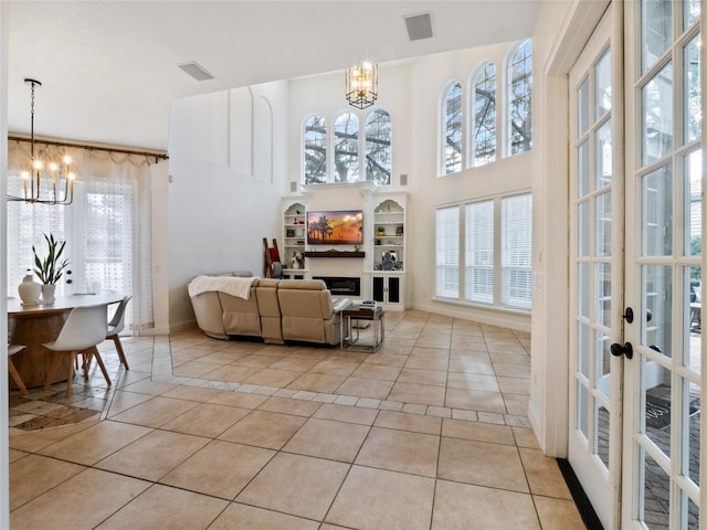 interior space with a wealth of natural light, light tile patterned floors, and an inviting chandelier