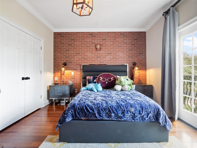 bedroom featuring wood-type flooring, brick wall, and ornamental molding