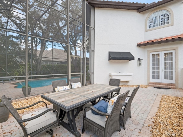 view of patio featuring a lanai and french doors