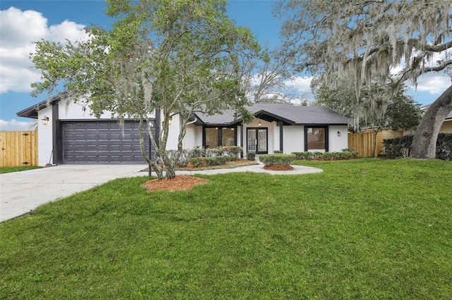 view of front of property with fence, concrete driveway, and a front yard