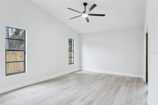 spare room with light wood-type flooring, baseboards, a ceiling fan, and lofted ceiling