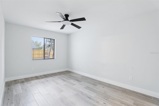 spare room with ceiling fan, light wood-style flooring, and baseboards