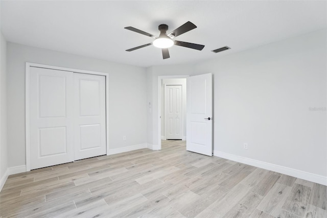 unfurnished bedroom featuring light wood finished floors, a closet, visible vents, ceiling fan, and baseboards