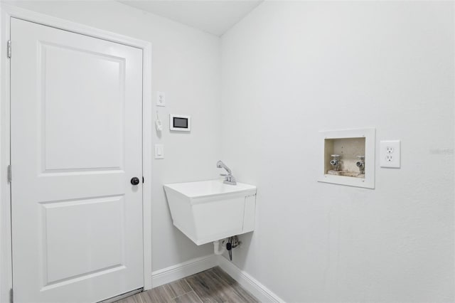 clothes washing area featuring washer hookup, laundry area, baseboards, and wood finished floors