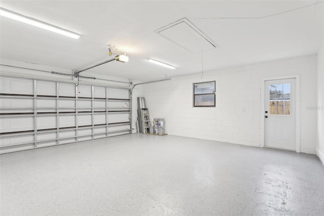 garage with concrete block wall and a garage door opener