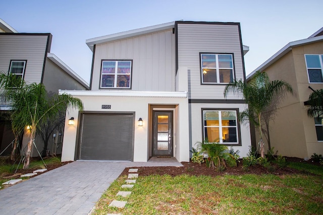 view of front facade featuring decorative driveway, an attached garage, and board and batten siding