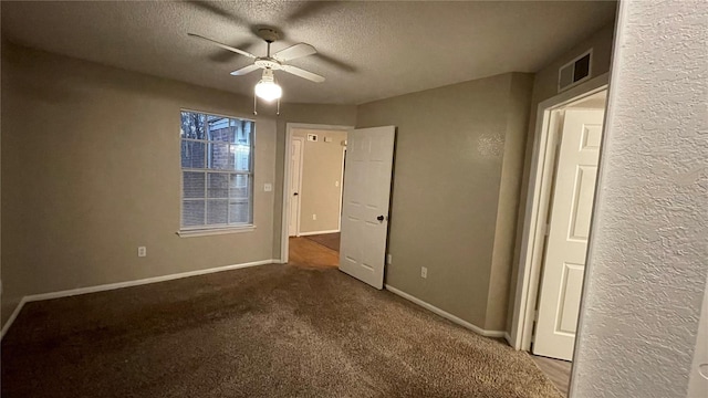 unfurnished bedroom with ceiling fan, carpet, and a textured ceiling