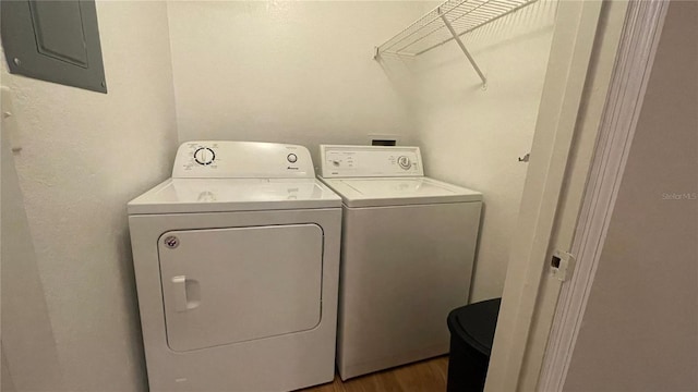 laundry area featuring dark hardwood / wood-style floors, electric panel, and washer and clothes dryer