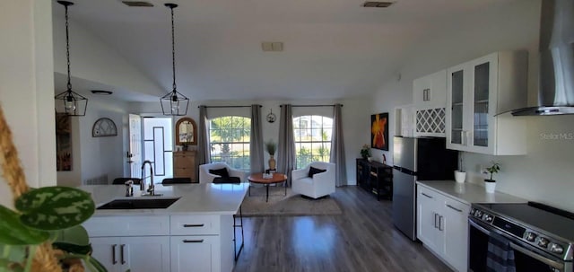 kitchen featuring sink, white cabinetry, appliances with stainless steel finishes, pendant lighting, and wall chimney range hood