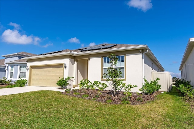 view of front of property featuring a garage, a front yard, and solar panels