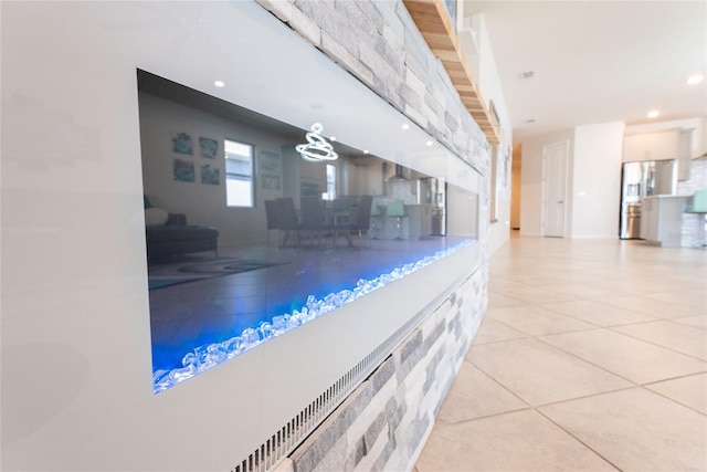 interior space with stainless steel fridge with ice dispenser and light tile patterned floors