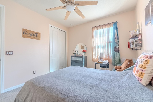 carpeted bedroom featuring ceiling fan and a closet