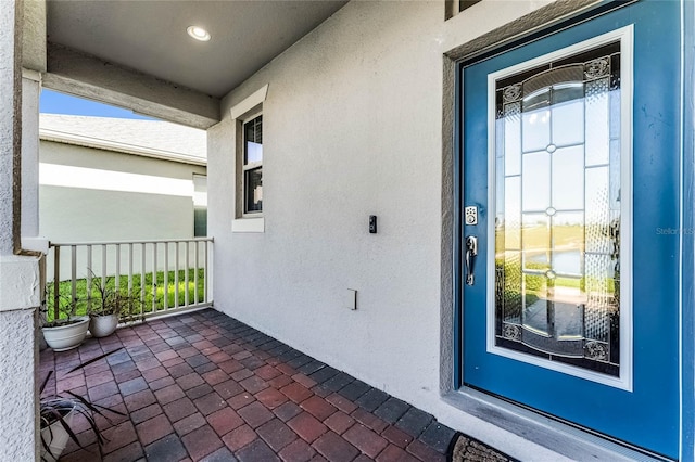 doorway to property featuring stucco siding