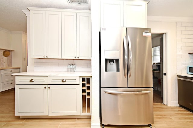 1611 Chestnut Ave, Winter Park, FL 32789 - kitchen with appliances with stainless steel finishes, ornamental molding, light wood finished floors, tasteful backsplash, and light countertops