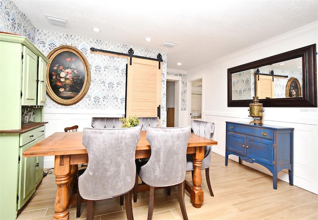 1611 Chestnut Ave, Winter Park, FL 32789 - dining room featuring a barn door, a wainscoted wall, crown molding, light wood finished floors, and wallpapered walls