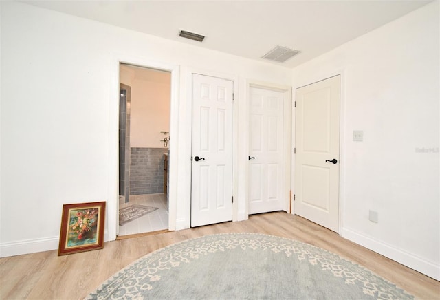 1611 Chestnut Ave, Winter Park, FL 32789 - unfurnished bedroom with wood finished floors, baseboards, and ensuite bath