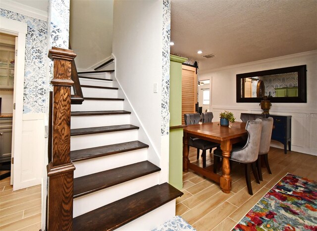 1611 Chestnut Ave, Winter Park, FL 32789 - stairway featuring ornamental molding, wood tiled floors, a wainscoted wall, a textured ceiling, and recessed lighting