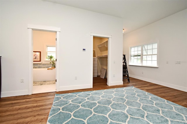 1611 Chestnut Ave, Winter Park, FL 32789 - unfurnished bedroom featuring wood finished floors, baseboards, a walk in closet, and ensuite bath
