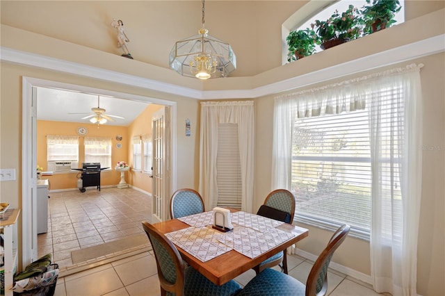 dining room featuring light tile patterned floors, ceiling fan with notable chandelier, and baseboards