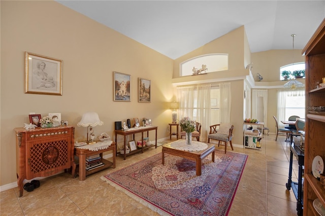 sitting room with light tile patterned floors, baseboards, and high vaulted ceiling