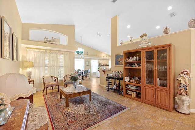 living room featuring light tile patterned flooring, visible vents, high vaulted ceiling, and baseboards