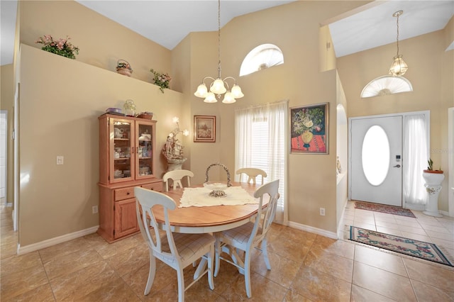 dining room with baseboards, a notable chandelier, and a high ceiling