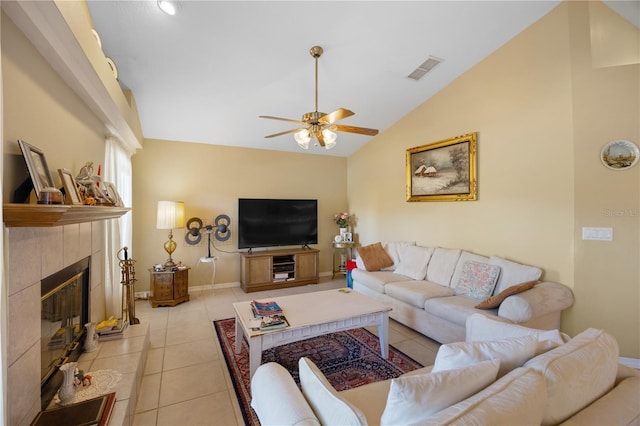 living room featuring visible vents, lofted ceiling, a fireplace, light tile patterned flooring, and a ceiling fan