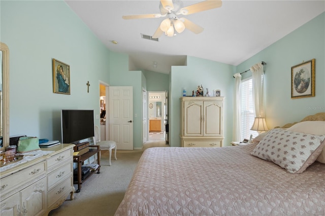 bedroom featuring visible vents, ceiling fan, vaulted ceiling, ensuite bathroom, and light carpet