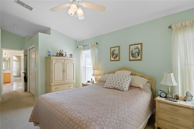 bedroom featuring visible vents, light carpet, a ceiling fan, a closet, and vaulted ceiling