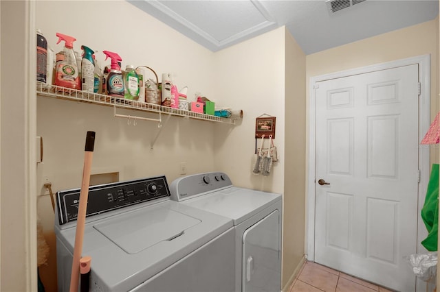 clothes washing area with visible vents, washing machine and dryer, light tile patterned floors, attic access, and laundry area