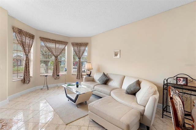 living room featuring a healthy amount of sunlight, a textured ceiling, and baseboards