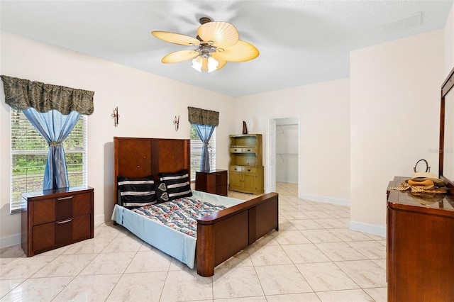 bedroom with ceiling fan, a spacious closet, baseboards, and visible vents