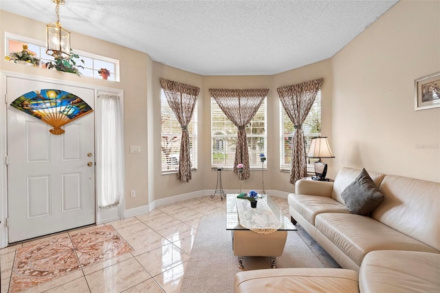 living room with a textured ceiling, marble finish floor, and baseboards