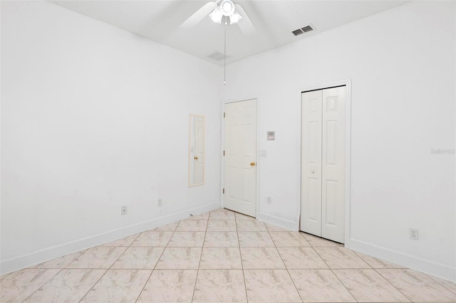 spare room with ceiling fan, visible vents, and baseboards