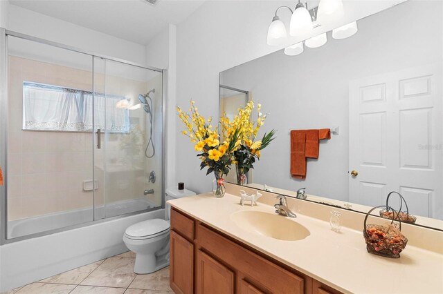 bathroom featuring toilet, shower / bath combination with glass door, tile patterned flooring, vanity, and a notable chandelier