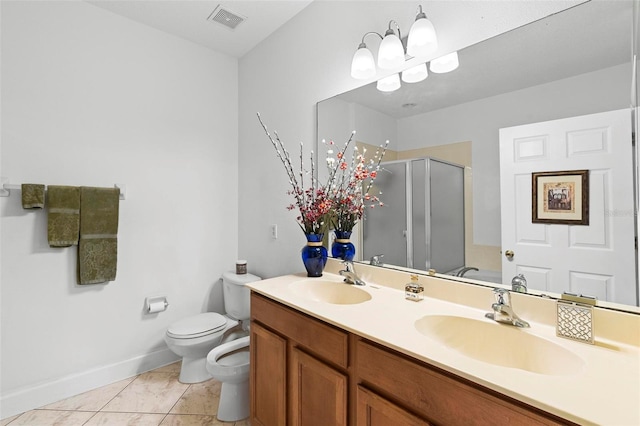 bathroom featuring toilet, a stall shower, a sink, and visible vents