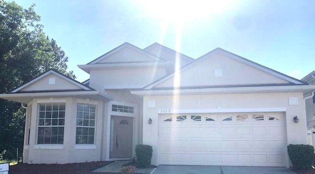 5509 Florence Harbor Dr, Orlando, FL 32829 - view of front of home featuring stucco siding, a garage, and driveway
