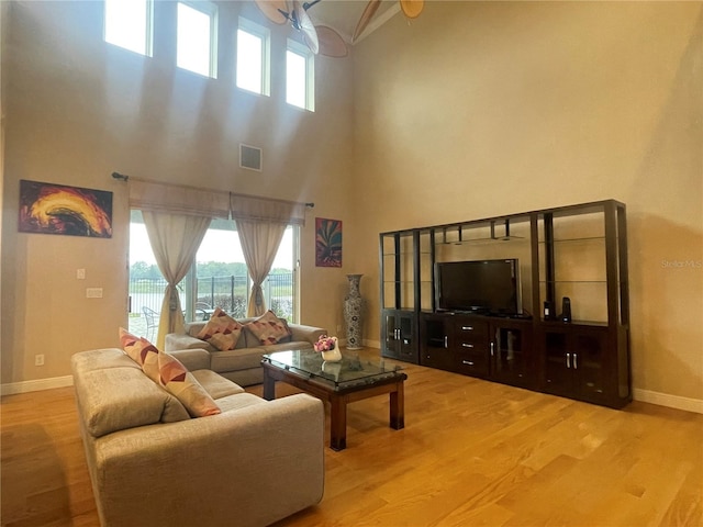 living area featuring visible vents, baseboards, and wood finished floors