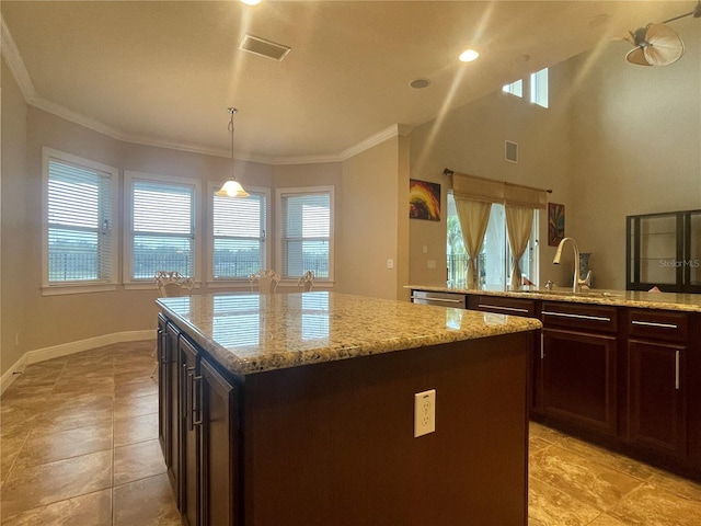 kitchen featuring a kitchen island, visible vents, a sink, and crown molding