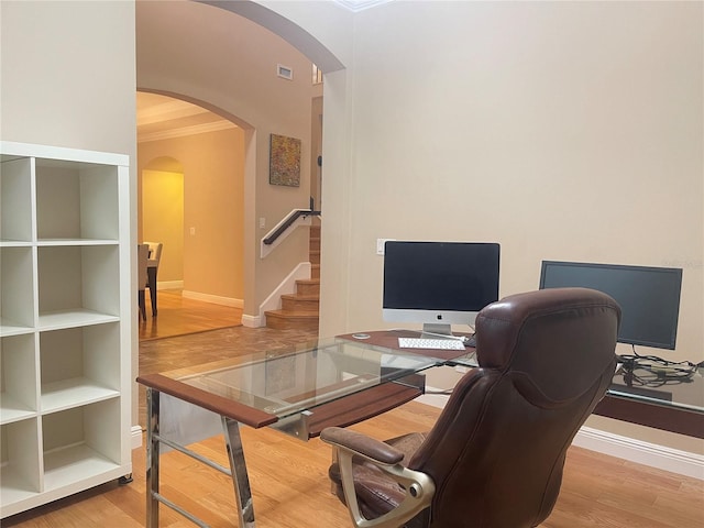 office area featuring arched walkways, visible vents, ornamental molding, wood finished floors, and baseboards