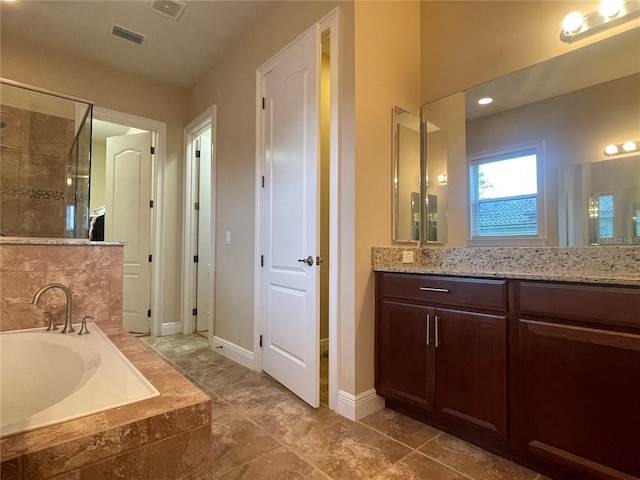 bathroom with vanity, a stall shower, a garden tub, and visible vents